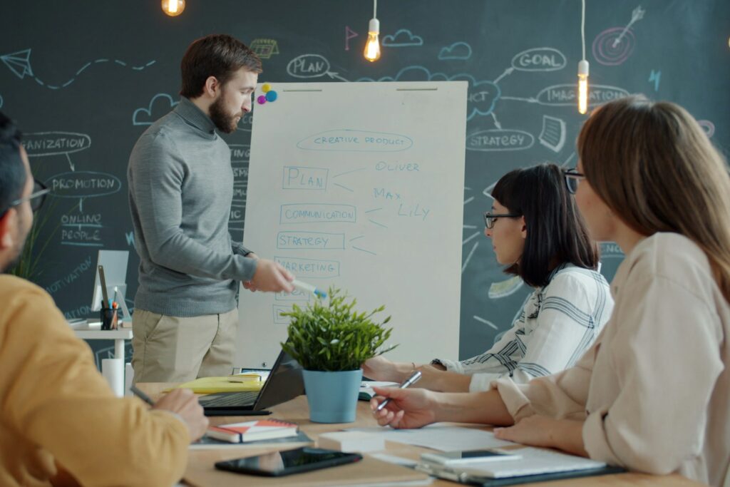 Team arbeitet eigenständig am Whiteboard – Ergebnis, wenn Führungskräfte Delegieren lernen