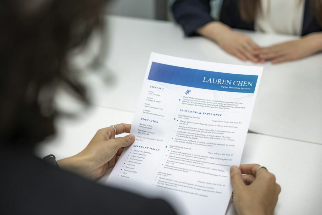 Employer Branding messbar machen: Eine Frau liest am Tisch aufmerksam einen Lebenslauf