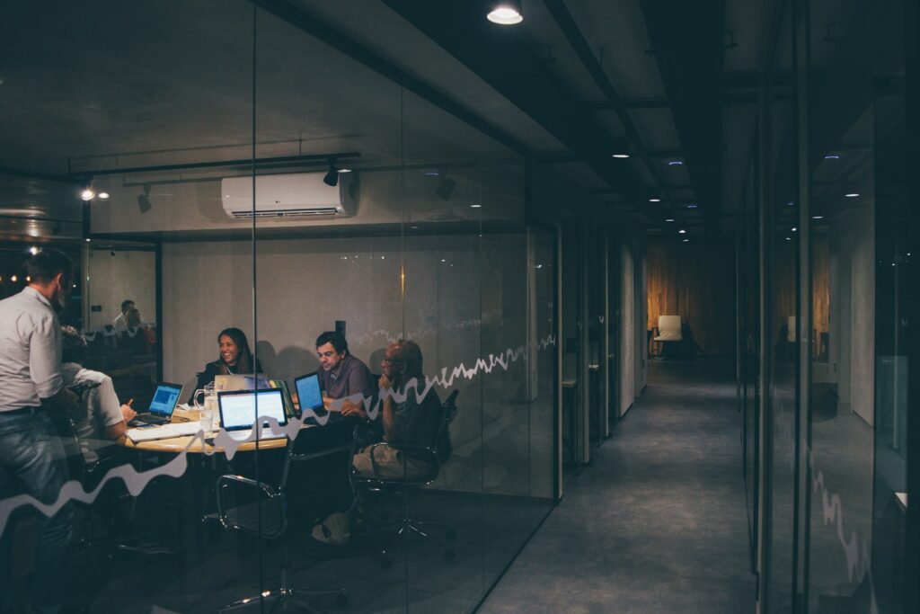 Hybrides Arbeiten mit Präsenztag: Team bespricht sich gemeinsam am Tisch im Büro