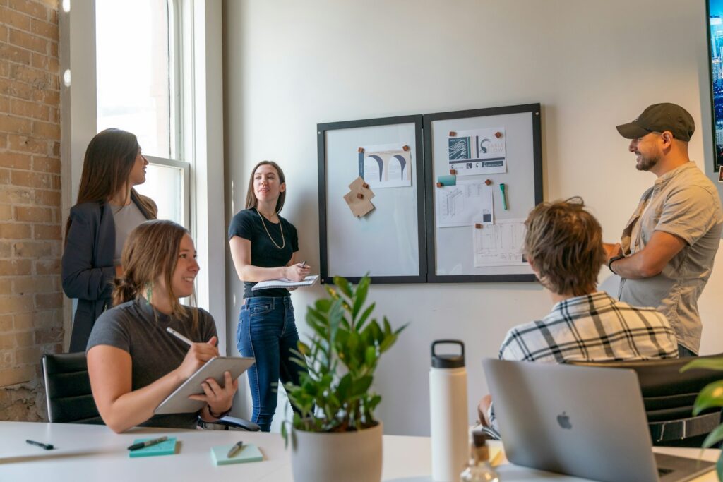 Strategie kommunizieren und zuhören: Gruppe im Gespräch während eines Meetings in einem hellen Büro