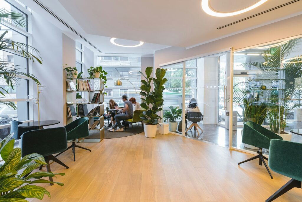 Moderne Lounge mit Pflanzen und Sitzgruppen als Begegnungszone beim Desk Sharing