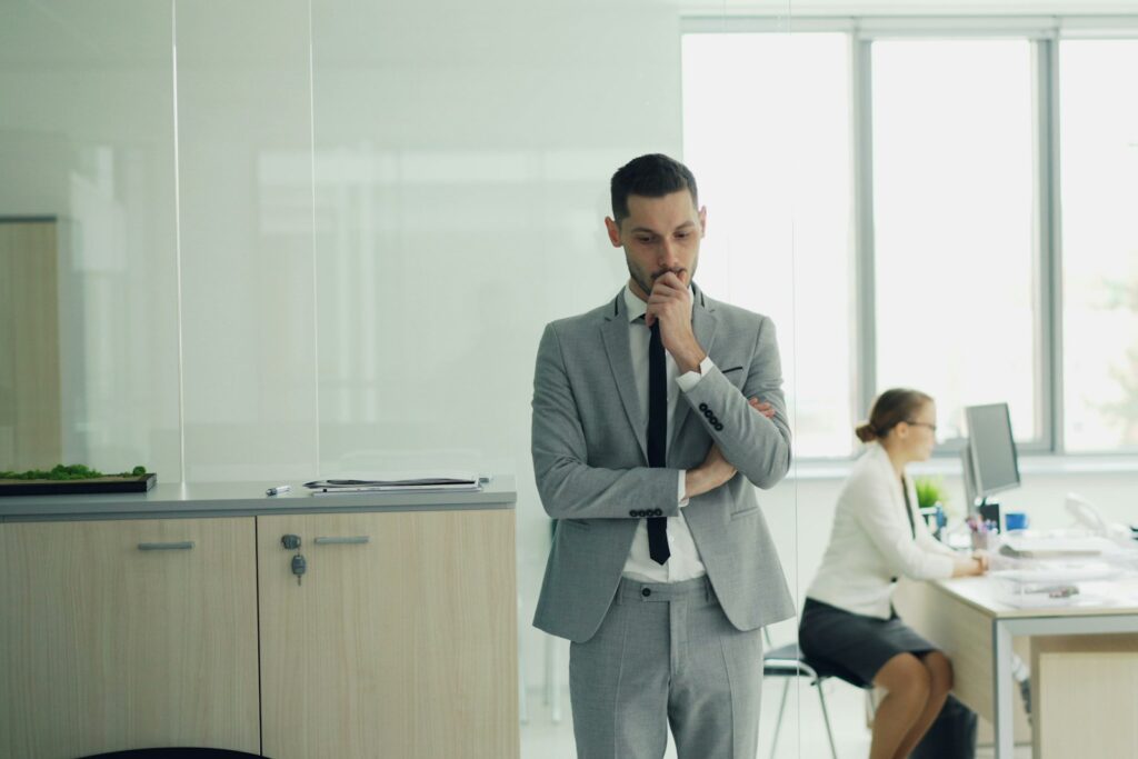 Job wechseln oder bleiben: Führungskraft denkt im Büro über den nächsten Schritt nach
