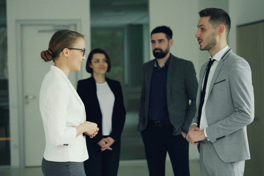 Kolleginnen und Kollegen im Gespräch auf dem Büroflur – laterale Führung lebt von informellen Netzwerken