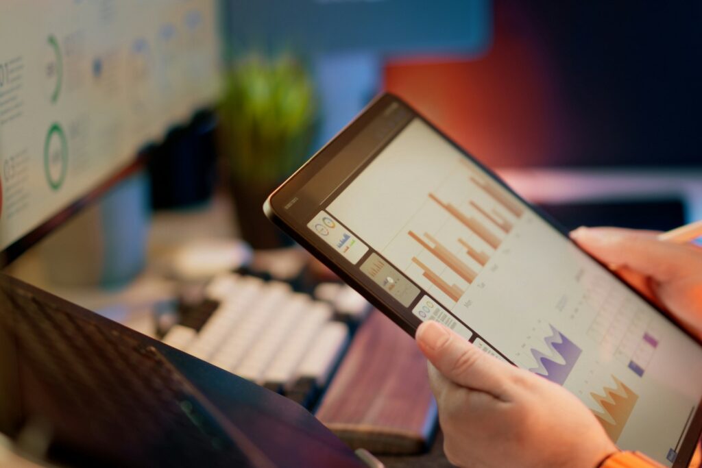 Management-KPIs analysieren: Person prüft Finanzkennzahlen auf einem Tablet