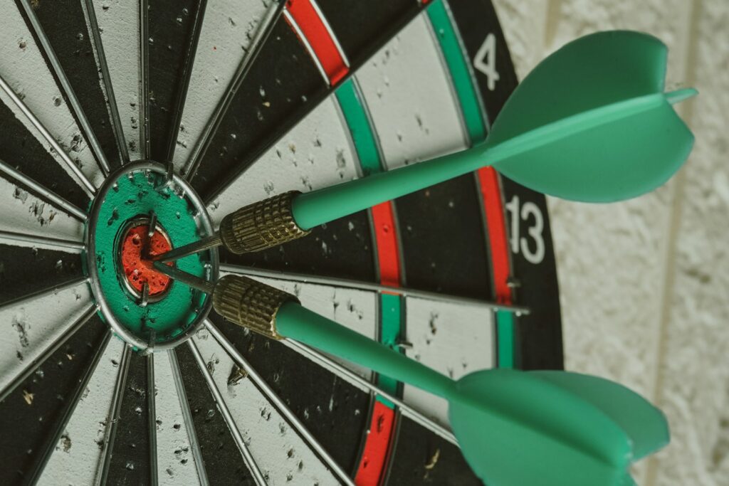 OKR-Methode: Darts treffen das Zentrum der Zielscheibe als Symbol für fokussierte Ziele