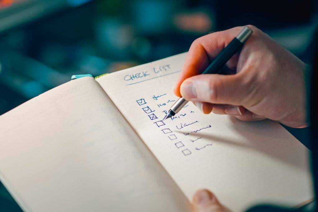 OKR-Methode in der Praxis: Hand hakt Punkte auf einer handschriftlichen Liste ab