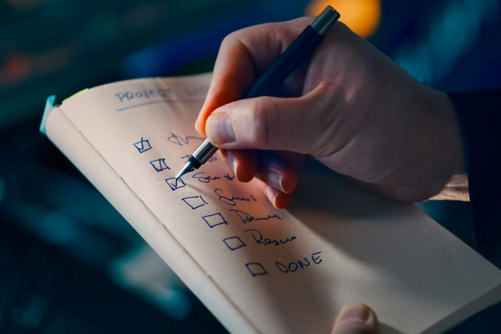 Hand hakt Punkte auf einer To-do-Liste ab – Priorisierung mit der 3-Prioritäten-Regel
