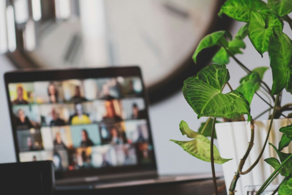 Laptop mit laufendem Videocall neben einer Zimmerpflanze, typische Szene beim Remote Onboarding im Homeoffice