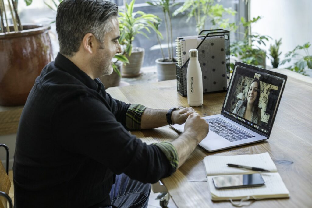 Mann arbeitet konzentriert am Laptop im Homeoffice während seiner ersten Tage im Remote Onboarding