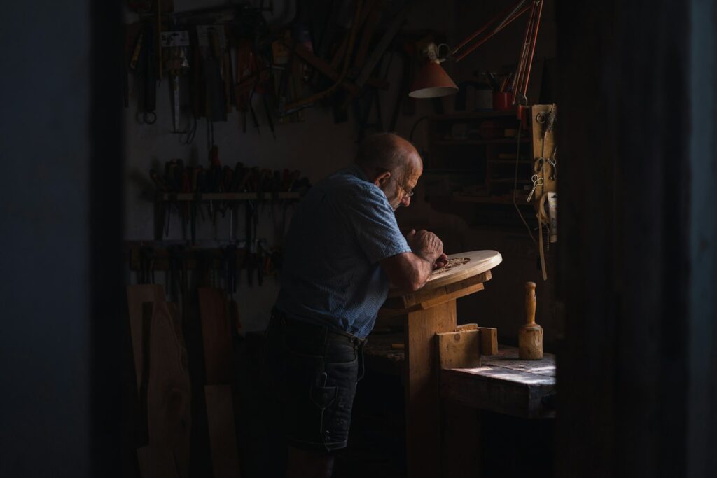 Unternehmensnachfolge im Handwerksbetrieb: Ein Mann arbeitet konzentriert in seiner Werkstatt